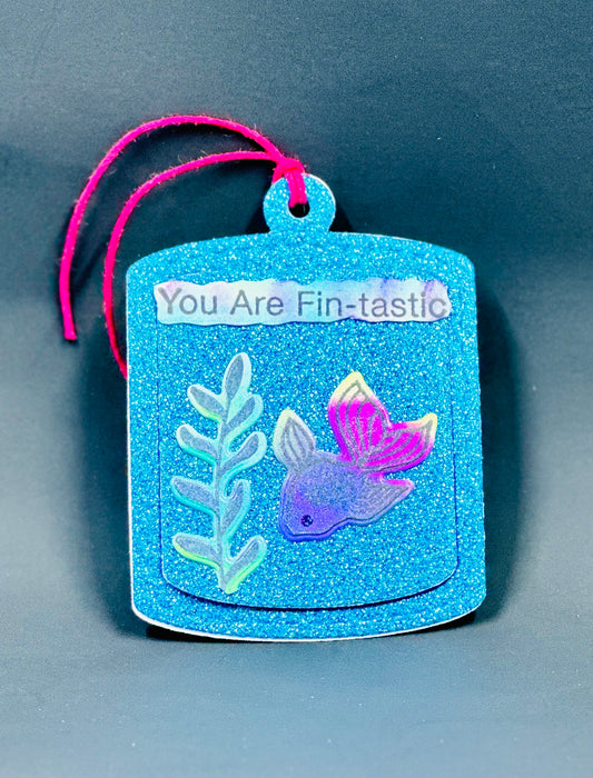 Glittered peek-a-boo gift tag featuring a bright, irridescent fish swimming towards some kelp.