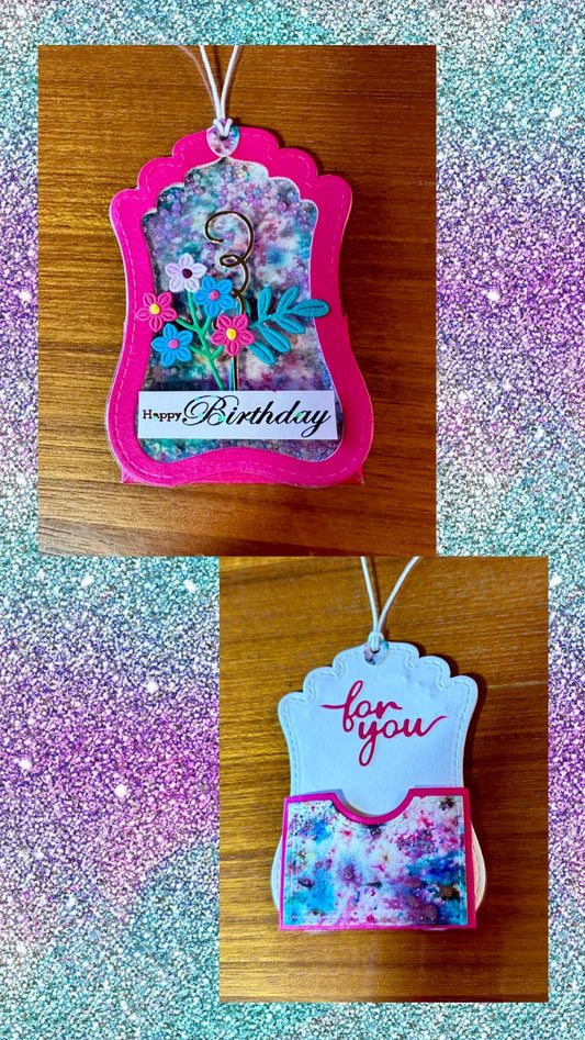 Pretty and colorful gift tag featuring a tiny floral arrangement set in front of a custom embelleshed background with shaker beads and a pocket in the back for a gift card.